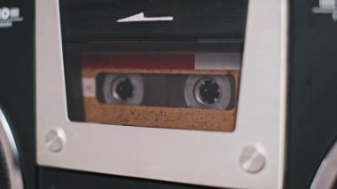 Eski tarz bir teybin içindeki klasik bir kasetin ayrıntılı görüntüsü. Nostalji, müzik ve geçmiş hakkında projeler için idealdir..