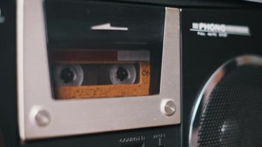 Antika bir kaset kaset retro-stil bir teybin içinde çalıyor. Görüntü, kasetlerin detaylarını ve müzik kutusunun estetiğini gözler önüne seriyor. Nostaljik ve geçmişe dönük projeler için mükemmel..