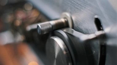 Metal Milli ve desen odaklı makaradan makaraya kayıt cihazının makro görüntüsü. Arka plandaki bokeh, klasik ses veya mühendislik temaları için ideal derinlik yaratıyor.