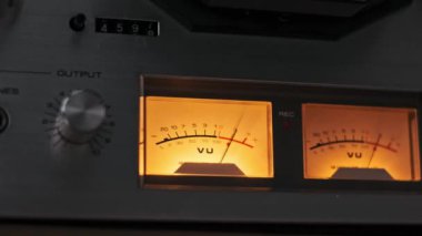 İki parlayan VU ölçer, gümüş düğmeler ve çıkış göstergelerinden oluşan klasik bir ses kontrol paneline ayrıntılı bir bakış. Analog ses ve retro tasarımın özünü yakalar.