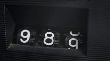 Dijital bir sayacın 987 'den 000' e geçişinin yakın çekimi. Geri sayım, bitiş veya geçiş dizileri için ideal.