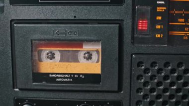 İçinde bant olan klasik bir kaset çaların detaylı bir görüntüsü. Odak noktamız kaset ve mekanik oyuncular. Retro ve nostaljik projeler için uygun.