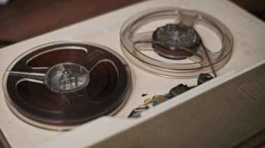 Eski bir makaradan makaraya makro görünüm, dönen makaralarla, retro ses kaydının özünü yakalıyor. Nostaljik, eski veya müzik temalı medya projeleri için ideal.