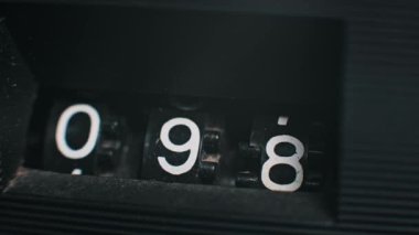 Eski bir mekanik sayaç sayacının 096 'dan 005' e geçişinin yakın çekimi. Bu görüntüleri retro, teknoloji veya sayma temaları için kullan.