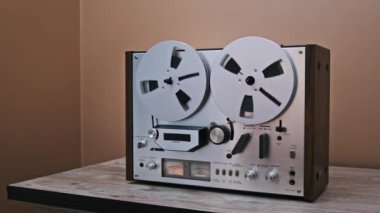 Bir el, makaradan makaraya eski bir kayıt cihazını aktifleştirir ve makarayı harekete geçirir. Analog sesin sıcaklığı ve nostaljiyi çağrıştırıyor..