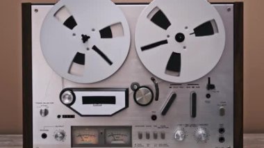 Beyaz makaralı, karmaşık kadranlı ve kontrollü klasik bir makaradan makaraya kayıt cihazının yakın çekimi. Retro ses ekipmanlarının nostaljik bir tasviri, klasik teknoloji ve müzik için mükemmel.