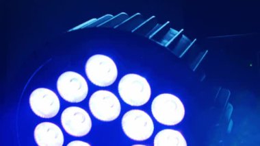 Yuvarlak bir LED sahne ışığı canlı mavi ve mor renkler ile titreşir, herhangi bir olay veya performans için dinamik ve enerjik bir atmosfer yaratır..