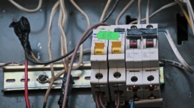 Bu yakın plan bir elektrik panelinin elektrik şalterleri ve yanmış kablo yalıtımı ile olası tehlikeleri gösteriyor. Güvenlik kavramları ve teknolojiyle ilgili videolar için harika..