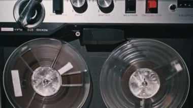 Eski bir makaradan makaraya kayıt cihazının yakın çekimi, makaralar dönüyor. Geçmişe dönük ya da müzik temalı projeler için mükemmel, nostaljik bir titreşim aktarmak için..