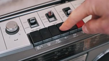 Bir parmak gümüş ve siyah boombox 'ın çalma tuşuna basar. Klasik, müzik veya teknoloji temalı projeler için mükemmel.
