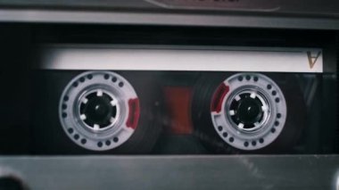 Bir dizi farklı kaset kasetleri klasik bir deste içinde döner, kaset çalarken çeşitli tasarım ve etiketleri gösterir.