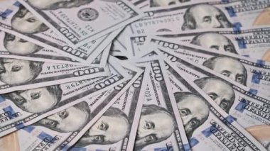 100 dolarlık gıcır gıcır banknotlar bir masanın üzerinde yelpaze şeklinde dizilir. İş ve finans konuları için mükemmel.