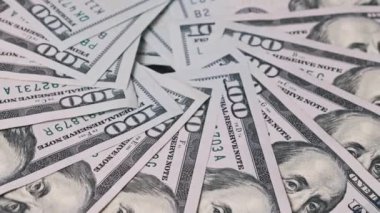 Birden fazla yüz dolarlık banknotlar fan şeklinde dizilir ve dairesel bir şekil oluşturur. Bu genel çekim zenginliği ve finansal bolluğu vurguluyor..