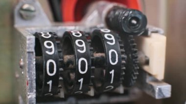Bir parmak retro mekanik sayacı ile etkileşime girer ve dönen sayısal görüntüyü elle sıfırlar. Elle kontrol, hassasiyet ve vintage aygıtları temaları anımsatır.