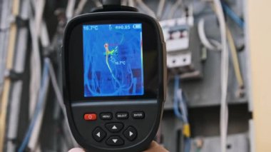 Bir el kamerası, enerji ve güvenlik analizi için kullanışlı olan açık devre kutusundaki elektrik kablolarındaki detaylı ısı değişimlerini yakalar.