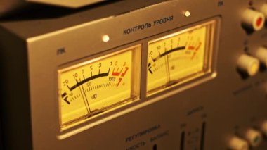 Gerçek zamanlı kayıt seviyelerinin, retro ses deneyimini vurgulayarak, sıcak tonlu çift ölçümlere odaklandığını gösteren, bobinden bobinli güvertedeki klasik ses seviyesinin ölçümlerini gösteren yakın çekim videosu