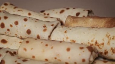 Bir el, ev yapımı kaliteyi vurgulayarak, görsel olarak cazip bir yığın arasından tek ve taze pişmiş bir krep seçer..