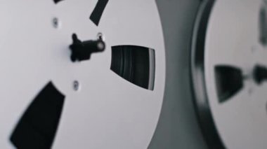 Teyp makaralar arasında hareket ederken makaranın makaranın görüntüsünü kapat, klasik tasarımı ve makaraların dönen hareketini göster.