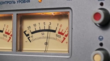 Analog bir VU sayacına yakın plan, net ses seviyelerini gösteren sıcak bir parıltı. Bu retro ekipman profesyonel ses kaydı ve karıştırma, hassasiyet ve nostaljinin birleştirilmesinde kullanılır..