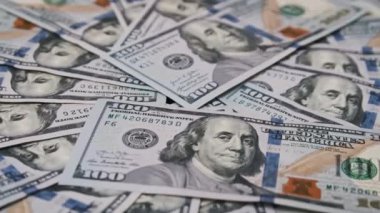 Yüzlerce dolarlık banknotlar dağınık bir şekilde gösteriliyor. Harcamaları, finansmanı ve zenginliği vurgulayan dağınık bir yığın oluşturuluyor. İş sunumları için ideal..