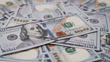 100 dolarlık banknotlar yavaş çekimde birbirinin üstüne yığılır. Birçok konu için finansal geçmiş ve ekonomik görüntü olarak ideal