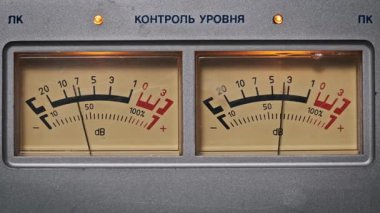 Hareket eden iğneli iki VU metrenin detaylı görüntüsü. Kontrol paneli ile eski tarz analog ekran gösteren klasik kayıt stüdyosu.