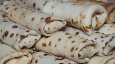 Blini olarak bilinen birden fazla doldurulmuş gözlemenin yakın plan görüntüsü, geleneksel Rus mutfağını resmetmek için ideal bir tabağa dizilmiş..