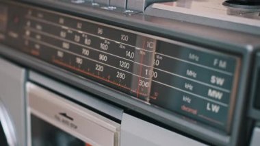 Radyo frekanslarını gösteren klasik bir ses oynatıcının yakın çekim görüntüsü. Bir retro aygıt üzerinde sayısal ölçekli ve etiketli analog görüntü.