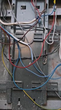 Açık bir elektrik kutusuna yakından bak. Renkli kablolara odaklan. Bağlı ve güvenli. Bir elektrik tesisatının karmaşıklığını gösteren dikey perspektif, ticari kullanım için mükemmel.