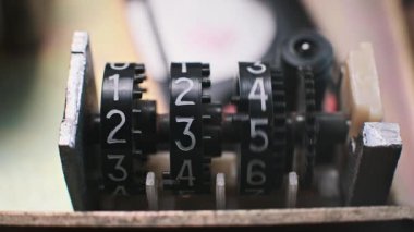 Eski bir mekanik sayacın yakın çekimi, değişen sayıları gösteren dönen parmaklar. Hesap yapmak için kullanılan bir retro aygıt. Zaman ve tarih temaları için mükemmel.