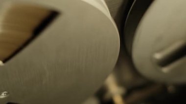 Dinamik olarak, eski bir makaradan makaraya dönen kasetçalar, çalma işleminin hareketini ve ekipmanların karanlık bir arkaplana karşı detaylarını yakalıyor..