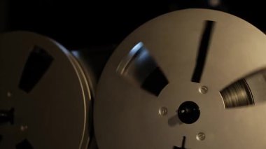 Oynatma sırasında retro-reel-to-reel oynatıcıdaki makaralar, karanlık bir ortamda çekiliyor, çarpıcı vurgu soluk tonlarla çelişiyor, hareket halindeki klasik sesin ayrıntılı görüntüsü