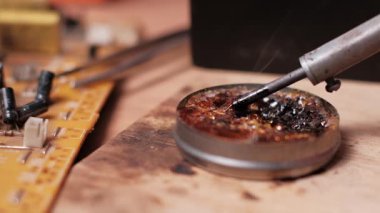Yavaş çekimde, reçine akışının içine batırılan kızgın bir lehim ucu yakalıyor ve görünür bir duman yaratıyor. Yakınlardaki elektronik bileşenleri lehimlemeden önce ipucunu temizlemek için kullanılır..