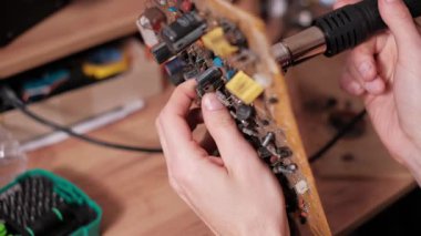 Eller dikkatlice yerleştirilmiş bir devre kartının ön kısmındaki özel bir parçayı ısıtmak ve bozmak için bir sıcak hava tabancası enjektörünü ayrıntılı bir elektronik onarım ya da yeniden çalışma görevi sırasında yerleştirin..