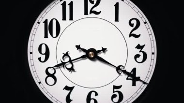 Yakın çekim zaman çizelgesi, siyah ellerin siyah sayılarla beyaz analog saat üzerinde hızla koştuğunu gösteriyor. Hızlı zaman geçişini ve aciliyeti vurguluyor..