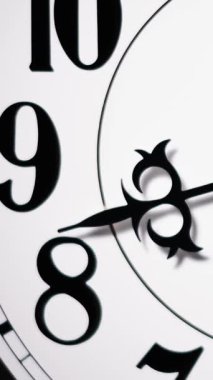 Dikey zaman çizelgesi, siyah ellerin beyaz saat üzerinde 8-10 rakamlarını geçerek hızlı zaman akışını vurguluyor..