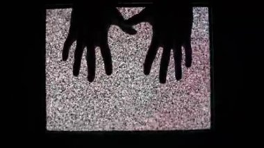 Bir çift ürkünç el silueti güçlü analog parazit parazitini gösteren eski bir televizyonun ekranına bastırıyor. Kapana kısılmak ya da iletişim kurmaya çalışmak gibi korkunç bir kavram..