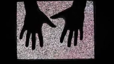 Gürültülü siyah-beyaz TV parazitinin ortasında siluetli bir el uzanıyor. Yukarıdan iki el belirir, birbirine doğru hareket eder, kısa bir süre temas eder, sonra ortadan kaybolur. Geçici, anlık bir bağlantıyı çağrıştırır