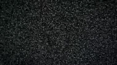 Yoğun statik gürültü gösteren televizyon ekranının makro görüntüsü, herhangi bir sinyal veya sinyal sorunu olmadığını gösteren siyah beyaz piksellerin rastgele titreşimi. Klasik görsel parazit dokusu.