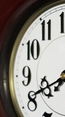 Süslü elleri 9, 10 ve 11 numaradan hızla geçen klasik saat yüzünün yakın görüntüsü öğle vakti ya da gece yarısına doğru hızla geçişi işaret ediyor..