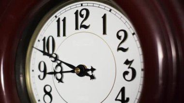Yakın plan zaman çizelgesine göre siyah eller, saat 8: 40 gibi beyaz kadranda başlayan 12 saatlik bir döngüde hızla dönüyor. Zaman kavramı çabuk geçiyor..