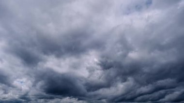 Yoğun gri fırtına bulutlarının kusursuz döngüsü gökyüzünde yavaşça ve uğursuzca hareket ediyor. Ağır, bulutlu koşullar, sürekli bir arka plan için mükemmel bir tehdit ve atmosfer ortamı yaratıyor..