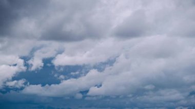 Zaman çizelgesi, gökyüzünde hızla hareket eden yoğun gri bulutlu fırtına bulutlarını gösteriyor. Kaygı verici ve dinamik bir atmosfer manzarası yaratıyor. Çalkantılı bulut örtüsünün arasında birkaç kuş görülebilir..