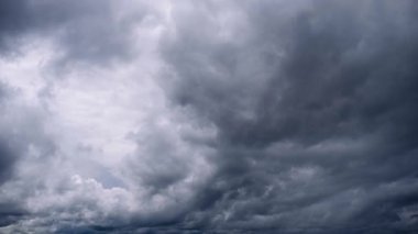 Uğursuz gri fırtına bulutları gökyüzünde hareket ederek dramatik ve çalkantılı bir atmosfer görüntüsü yaratıyor. Ağır, kara bulut örtüsü yaklaşan bir fırtınayı gösteriyor, dinamik bulut hareketleriyle.