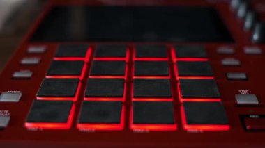 Kırmızı ritim tutucularda dinamik ışık gösterimi. Aydınlatıcılar. Parlayan düğmelerin yakın plan görüntüleri bir stüdyodaki profesyonel ses çalışma istasyonunda sıcak ve serin renkler arasında dönüyor..