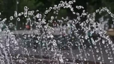 Güzel bir yavaş çekim fıskiyeden gelen sayısız su damlasını bulanık bir park arka planına çarpar. Dinamik, akışkan hareket canlandırıcı ve büyüleyici bir görsel doku yaratır..