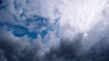 Zaman çizelgesi dramatik fırtına bulutlarını yakalıyor. Parlak mavi gökyüzünün parçalarını ortaya çıkarmak için dağılıyor. Karanlık, bulutlu havadan açık gökyüzüne geçiş umudu ve değişimi simgeliyor..