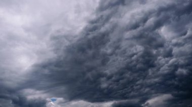 Tehditkar, gri fırtına bulutlarının kaynaması ve çalkalanması. Çalkantılı, ağır bulut kütlesi, dramatik klipler için mükemmel bir kıyamet ve yoğun atmosfer arkaplanı yaratır..