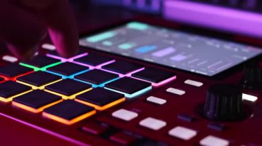 Müzisyenlerin yakın plan çekimleri canlı, aydınlık pedleri kırmızı bir vurucuya bastırarak, dinamik, renkli ışık değişimleriyle loş bir stüdyo ortamında elektronik müzik yaratıyorlar..