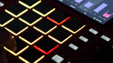 Müzisyenlerin elleri dijital ritim üretim çalışma istasyonunda çok renkli davul pedlerine basarak ritim yaratıyor..